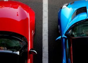 Red car and blue car parked next to one another