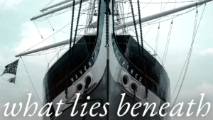 A ship with text "what lies beneath"