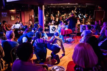 Jazz club venue with singers and instrumentalists performing in front of an audience